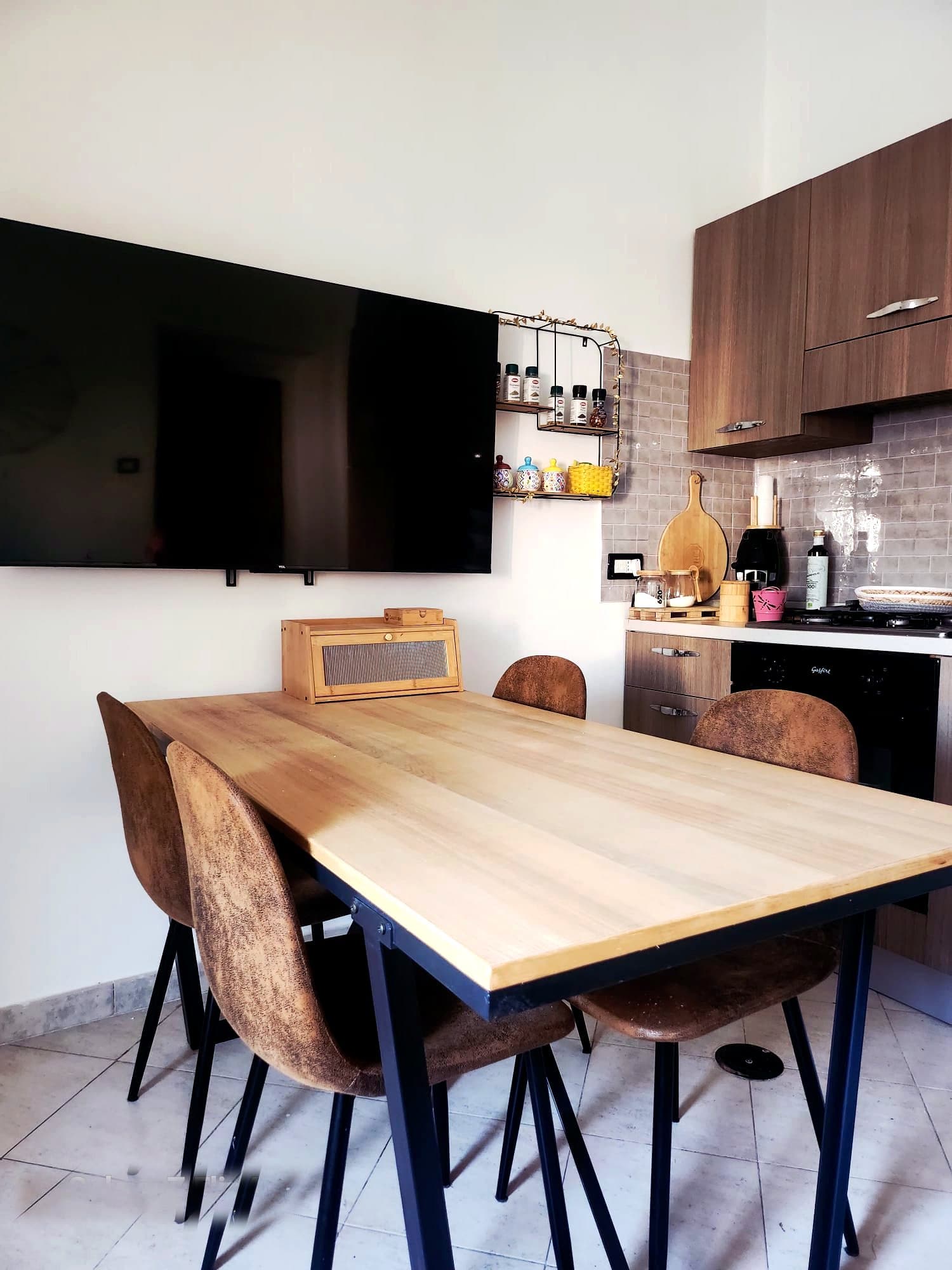 Soggiorno con cucina, tavolo in legno e Smart TV